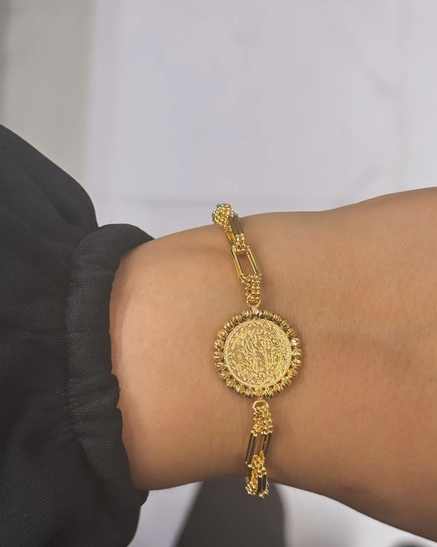Gliederarmband mit rundem Münzelement am Handgelenk